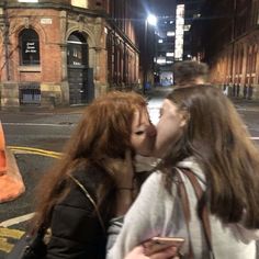 two women kissing each other on the street