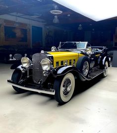 an old fashioned car is parked in a garage