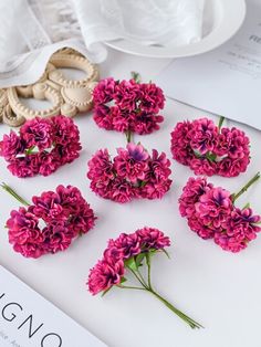 pink flowers are arranged on a white table