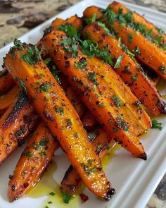 grilled carrots with herbs and oil on a white plate