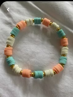 a bracelet with beads on it sitting on a bed