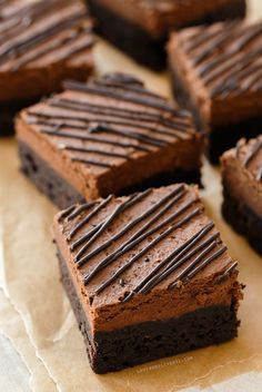 several pieces of chocolate cake sitting on top of parchment paper