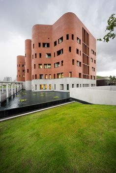 the building is made out of red bricks and has green grass in front of it