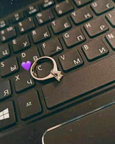 a heart shaped ring sitting on top of a laptop keyboard