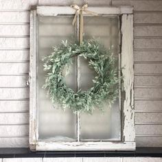 an old window with a wreath hanging on the front door and words diy farmhouse decor above it