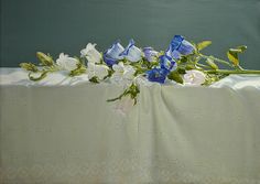 a painting of blue and white flowers sitting on a table cloth with green leaves in the background