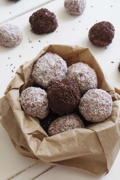 a paper bag filled with chocolate covered donuts on top of a white countertop