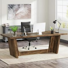 a wooden desk with a laptop on it in an empty room next to a window