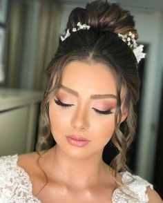 a woman in a wedding dress with her eyes closed and makeup done by the bride