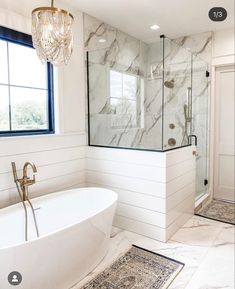 a bathroom with a tub, shower and rugs on the floor