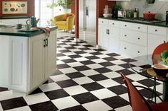 a kitchen with black and white checkered flooring next to a dining room table