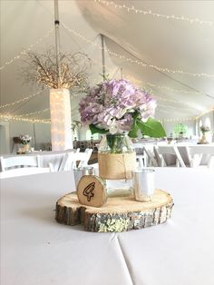 the centerpieces are made out of wood and decorated with flowers in mason jars