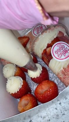 strawberries are being poured into ice cream in a bowl with pink ribbon around it