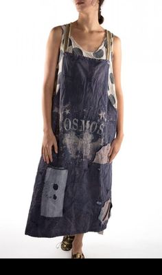 a woman standing in front of a white background wearing an apron with the word ostrich printed on it