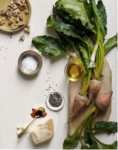 some vegetables are on a cutting board with seasonings and spices next to each other