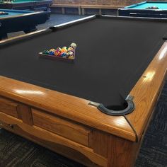 a pool table with several billiards on it in a room full of tables