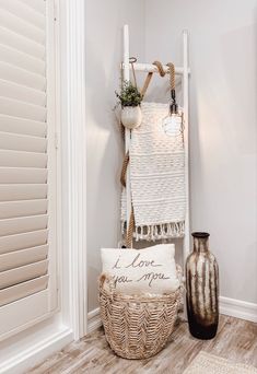 a basket and two vases are on the floor in front of a white wall