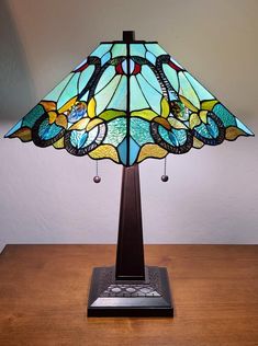 a stained glass lamp sitting on top of a wooden table