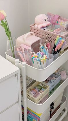 an organized drawer with toothbrushes, pens and other items in the bins