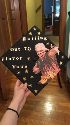 a person holding up a graduation cap with the words rolling out to flavor town on it