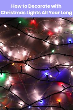 colorful lights are hanging from the branches of a tree in front of a dark background