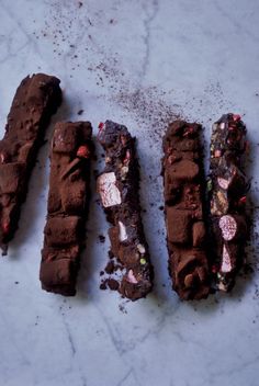 four pieces of chocolate cake sitting on top of a counter