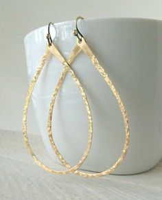 large gold hoop earrings on a white cup