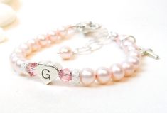 "Personalized Pink Pearl Bracelet for Newborn, Infant, Baby, or Little Girl. This keepsake gift is created with 5mm pink Swarovski crystal pearls, pink Swarovski crystals, a sterling silver heart-shaped initial, 2 sparkling sterling silver stardust spacers, and a heart shaped lobster clasp with a 1/2\" \"Grow-With-Me\" extender chain. You also have your choice of one sterling silver charm, placed near the clasp. ALL metal components are sterling silver. (Star of David charm is silver plated) Arr Pink Heart Charm Bracelet For Anniversary, Elegant Adjustable Heart Bracelet For Birthday, Pink Heart-shaped Bracelet For Personalized Gift, Cute Personalized Heart Bracelet For Birthday, Adjustable Name Bracelet With Heart Charm For Wedding, Adjustable Heart-shaped Name Bracelet For Wedding, Adjustable Pink Heart Bracelet, Personalized Round Bracelets, Adjustable Pink Jewelry For Baptism