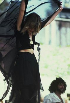 a woman holding an umbrella on top of a stage