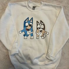 These Warm Cozy Custom Made Shirts Are So Cute For Your Little One!! Bluey Merch For Adults, White Long Sleeve Fun Sweatshirt, Blue Long Sleeve Shirt With Cartoon Print, Blue Cartoon Print Long Sleeve Shirt, Playful White Long Sleeve Sweatshirt, White Cotton Shirt With Cartoon Print, Fun Blue Cotton Sweatshirt, Blue Cotton Fun Style Sweatshirt, Cute White Sweatshirt With Cartoon Print