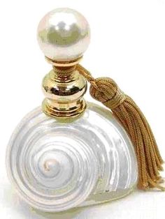 a white bottle with a tassel on the top and a gold cap around it