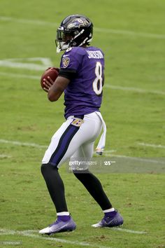 a football player holding a ball on the field