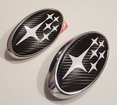 two black and white stars are on the side of an oval emblem with chrome trim