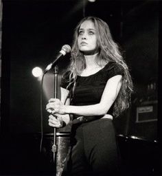 a black and white photo of a woman holding a microphone in front of a mic