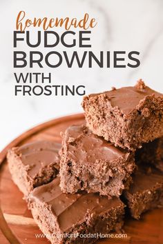 chocolate fudge brownies with frosting stacked on top of each other in a wooden plate