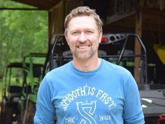 a man standing in front of a tractor with the words smoothth's first on it