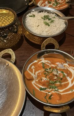 there are many different types of food in bowls on the table, including rice and curry