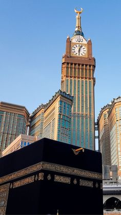 a large building with a clock on it's side in front of other buildings