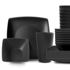 black dishes and cups are stacked on top of each other in front of a white background