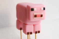 a close up of a pink toy animal on toothpicks