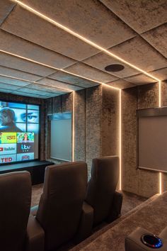 an empty room with two recliner chairs and a projector screen in the corner