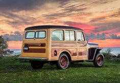 an old car is parked on the grass by the water at sunset or dawn with clouds in the sky