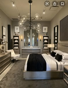 a bedroom with a large bed and chandelier hanging from the ceiling