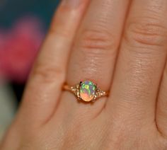 This stunning Stardust ring draws the eye with its dazzling opal center and intricate details, all set against a backdrop of glittering and golden metals. The ring's opal is surrounded by a lacy ornamentation and adorned with twinkling diamonds for a look that dazzles and captivates. If you're looking for an engagement ring, gift, or something to simply show off to the world, this is the ring for you! Opal, Diamond and Ring Info: Opal: 8x6 mm (.95 cts) Pictures taken in various lightings Diamond Gold Opal Ring With Accent Stones, Round Opal Ring With Intricate Design For Wedding, Intricate Round Opal Ring For Wedding, Oval Opal Ring With Intricate Design For Wedding, Opal Wedding Ring With Intricate Design, Wedding Opal Ring With Intricate Design, Heirloom Ethiopian Opal Ring For Wedding, Heirloom Ethiopian Opal Wedding Ring, Opal Ring With Intricate Design As A Gift