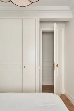 a bedroom with white walls and closets in the corner, along with a bed