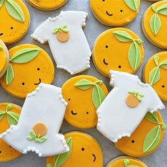 decorated cookies with oranges and green leaves are arranged on a sheet of tin foil