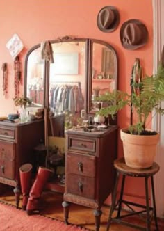 a room with a mirror, stool and potted plant on the floor in front of it