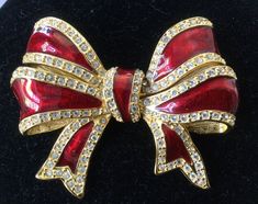 "Nice looking and super elegant, Joan Rivers' large red enamel knotted bow pin. Gold tone trim with clear pave crystals. No scratches. Excellent vintage condition. No missing stones. Secure clasp. Please look carefully. 1990s 2 3/4\" x 2 1/8\" 46.8 grams wt. Attention: All items are listed to the best of our observation, but they are pre-owned and pre-loved (meaning we may have missed something minor and/or be in need of light cleaning.) Please read our shop policies and/or convo us before makin Joan Rivers Jewelry, Gold River, Jewelry Board, Bone Necklace, Blue Topaz Earrings, Christmas Pins, Joan Rivers, Topaz Earrings, Beaded Choker Necklace