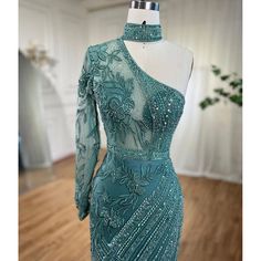 Striking turquoise color exudes vibrancy and elegance. One-shoulder design adds a touch of sophistication. Mermaid silhouette accentuates curves for a flattering fit. Adorned with intricate beadwork for a glamorous look. Perfect for women's wedding parties and formal events. Crafted with high-quality materials for comfort and durability. Embodies grace and style for a memorable occasion. Green Gown With Asymmetrical Neckline For Evening, Green Asymmetrical Neckline Evening Gown, Green Evening Gown With Asymmetrical Neckline, Green Fitted Gown With Asymmetrical Neckline, Green Fitted Evening Dress With Asymmetrical Neckline, Fitted Green Evening Dress With Asymmetrical Neckline, Elegant Turquoise Evening Dress, Elegant Turquoise Gown For Wedding, Elegant Turquoise Evening Dress For Prom