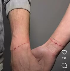 two people are holding hands with red lines on their wrist and the other hand has a heart